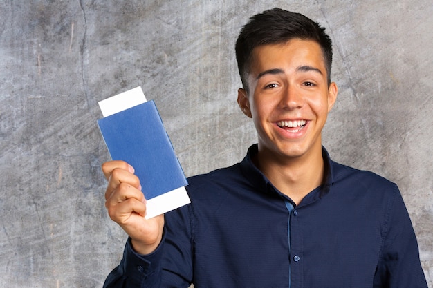 Homem, sorrindo, olhando câmera, e, segurando, bilhetes, com, passaporte Foto Premium