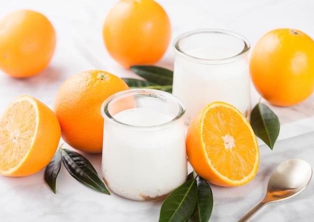 Iogurte de sobremesa creme fresco com laranjas cruas na placa de madeira Foto Premium