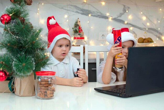 Irmão e irmã com chapéu de papai noel estão se divertindo. crianças à