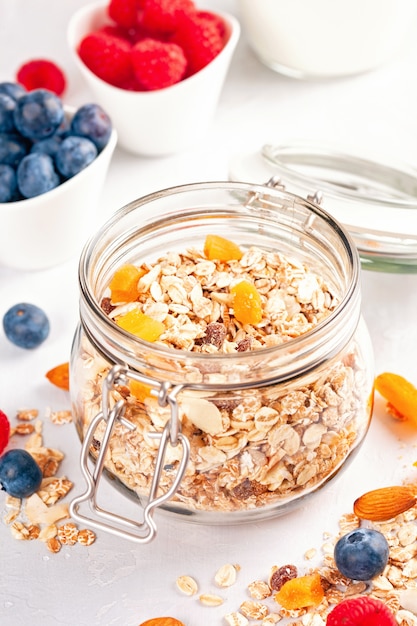 Jar com granola caseira ou muesli de aveia com nozes, frutas secas e frutas frescas. Foto Premium