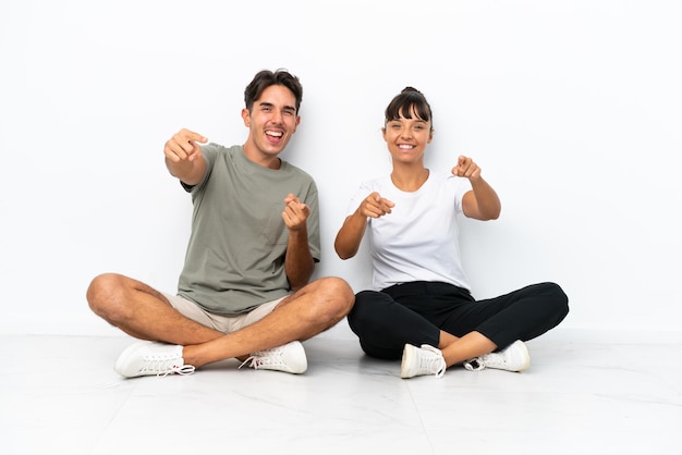 Jovem Casal De Ra A Mista Sentado No Ch O Isolado No Fundo Branco