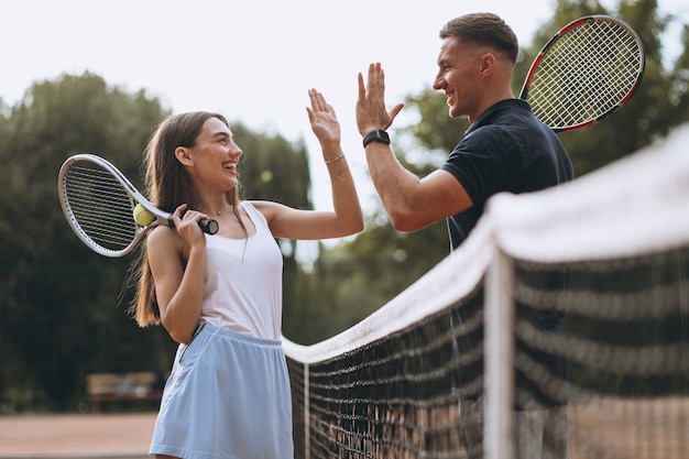 Jovem casal jogando tênis na quadra Foto gratuita