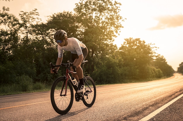 Jovem Ciclista Andando De Bicicleta Em Uma Estrada Aberta Ao P R Do Sol