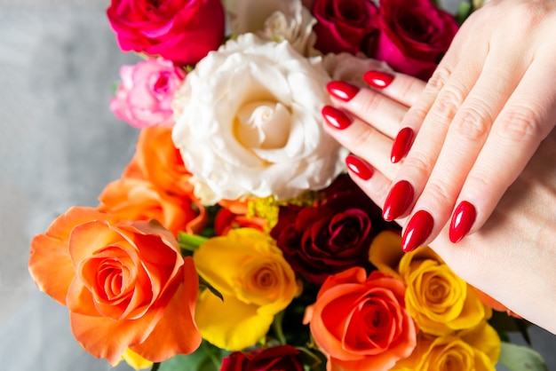 Jovem está mostrando suas unhas vermelhas manicure Foto Premium