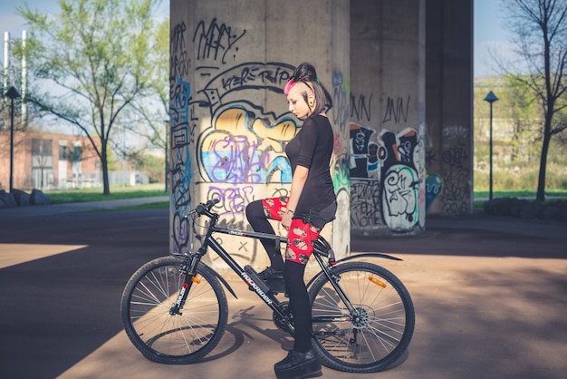 Jovem linda punk escuro garota andando de bicicleta | Foto Premium