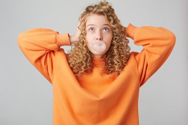 Jovem Loira Encaracolada Vestida Com Um Su Ter Laranja Brilhante Grande Demais Em P Com As M Os