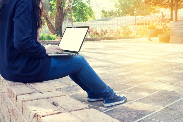 Jovem mulher asiática usando laptop no parque. Foto Premium