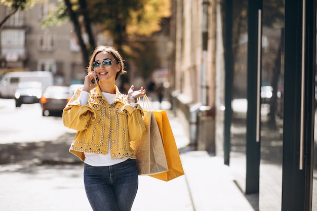 Jovem mulher com sacolas de compras na cidade Foto gratuita