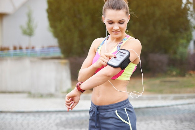 Jovem mulher exercitando ao ar livre. minha música favorita me ajuda a praticar esportes Foto gratuita