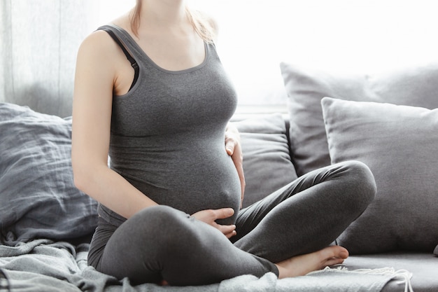 Jovem mulher grávida tocando sua barriga Foto gratuita
