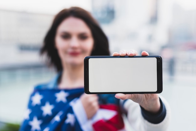 Jovem mulher mostrando smartphone com tela em branco Foto gratuita