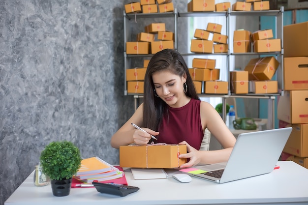 Jovem mulher usando o computador portátil. sucesso dos empresários em fazer negócios. expedição onlin Foto Premium