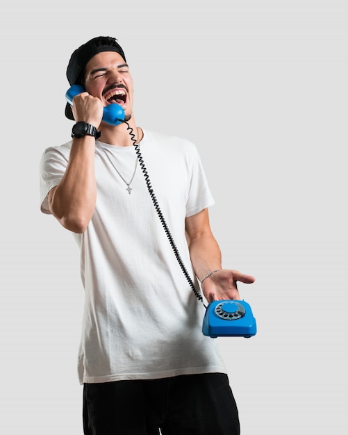 Jovem rapper homem rindo alto, se divertindo com a conversa, chamando um amigo ou um cliente Foto Premium