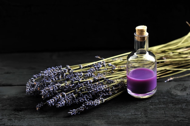 Lavanda, óleo de lavanda no fundo escuro de madeira Foto Premium