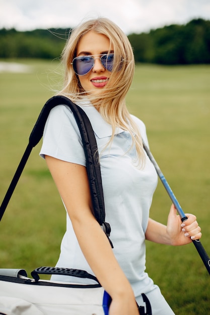 Linda garota jogando golfe em um campo de golfe Foto gratuita