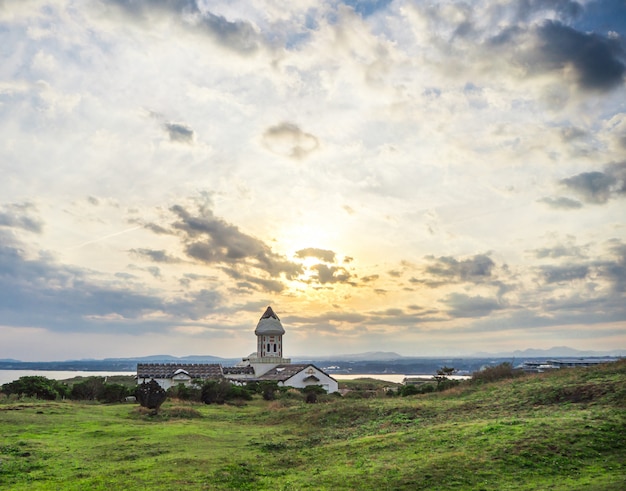 Linda igreja católica na manhã com o nascer do sol e o céu azul em seopjikoji mount jeju island, coréia do sul Foto Premium