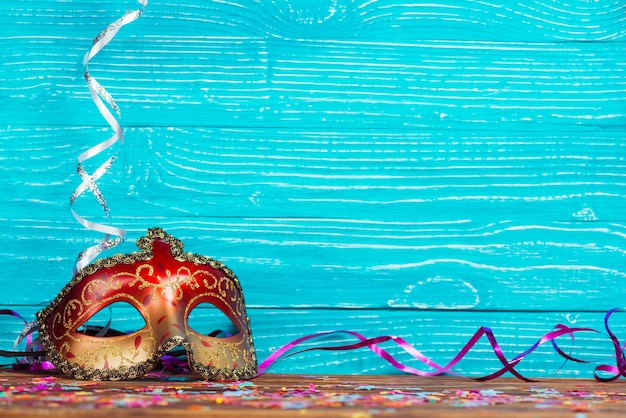 Linda máscara de carnaval em fundo de madeira azul Foto gratuita