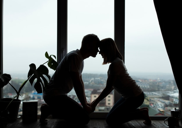 Lindo Casal Posando Ao Lado Da Janela Foto Grátis