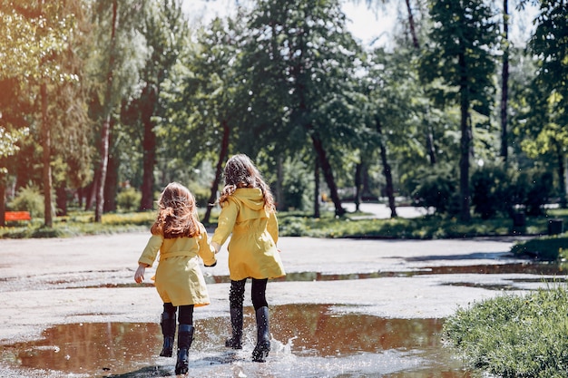 Lindos filhos plaiyng em um dia chuvoso Foto gratuita