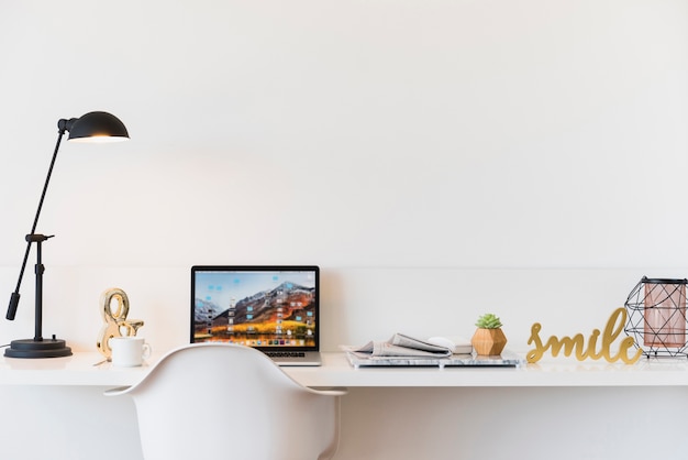 Local de trabalho com o laptop na mesa em casa Foto gratuita