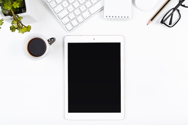 Local de trabalho com tablet e xícara de café Foto gratuita