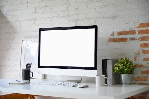 Local de trabalho do sotão com computador de mesa de tela em branco de maquete e acessórios de escritório em casa Foto Premium