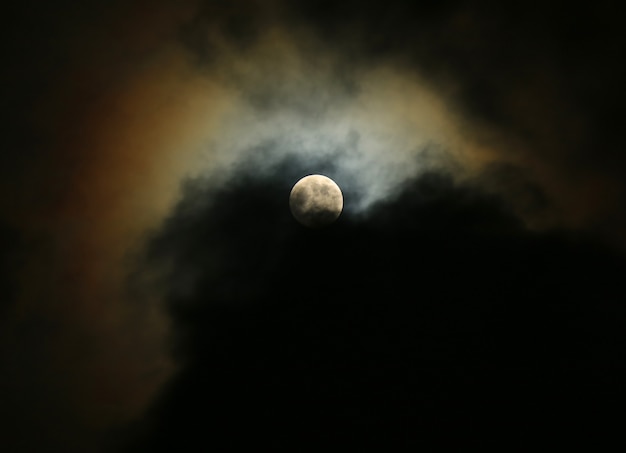 Lua no céu nublado à noite com luar refletindo na nuvem Foto Premium