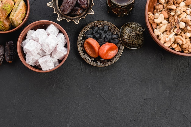 Lukum delicioso; frutos secos e nozes no pano de fundo texturizado preto Foto gratuita
