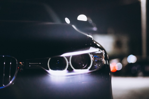 Luzes da frente do carro à noite na estrada Foto gratuita