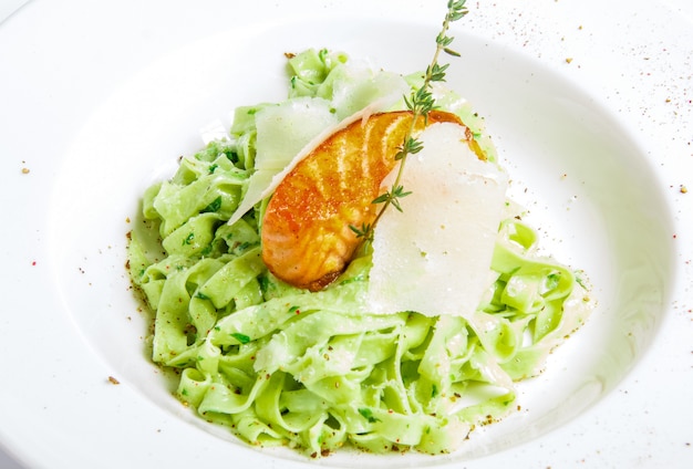 Macarrão verde com peixe grelhado Foto gratuita