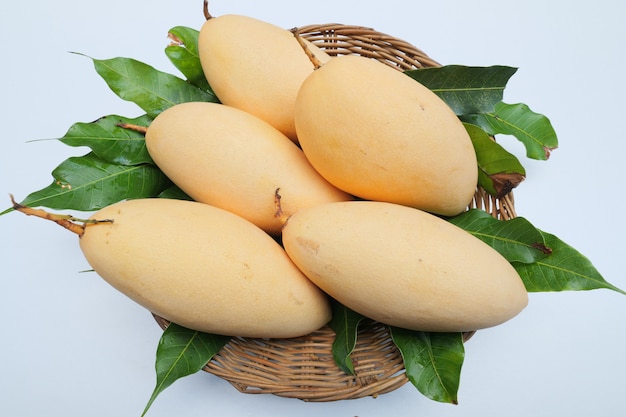 Madura manga frutas na cesta com folhas Foto Premium