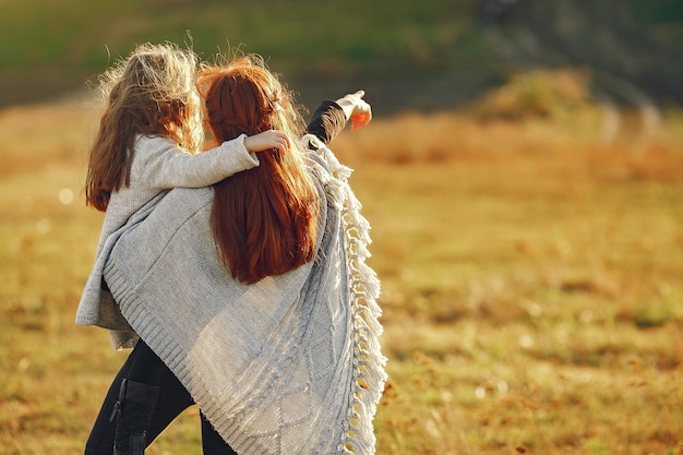 Mãe com filha brincando em um campo de outono Foto gratuita