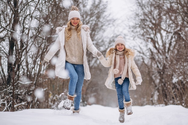 Mãe com filha caminhando juntos em um parque de inverno Foto gratuita