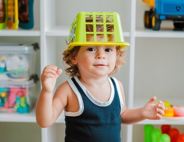 Mãe e criança brincam no chão no berçário. mãe e bebê menino estão fazendo com brinquedos coloridos de plástico. Foto Premium