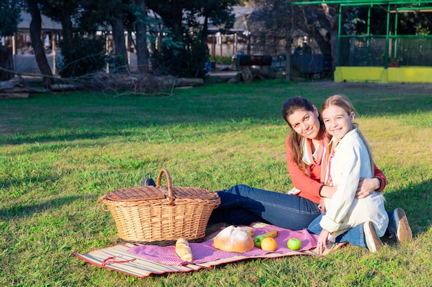 Mãe e filha num piquenique no parque Foto gratuita