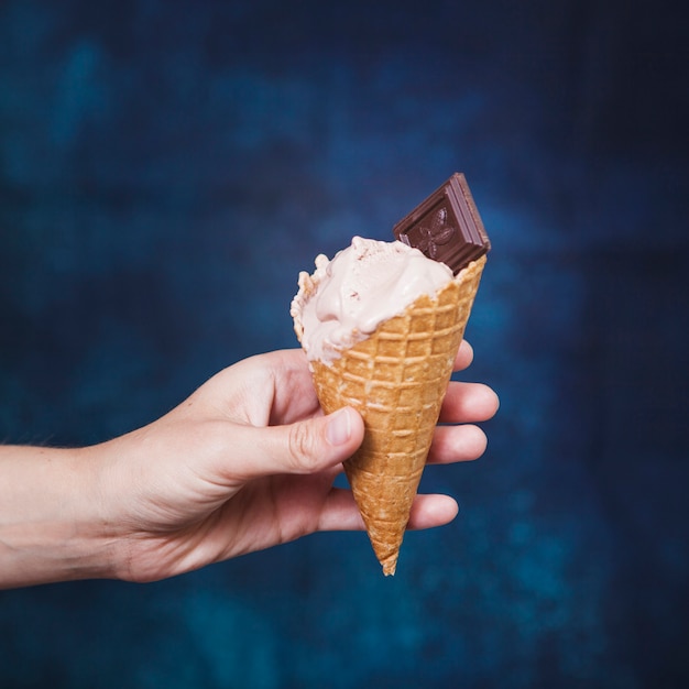 Mão de colheita segurando o cone com sorvete Foto gratuita