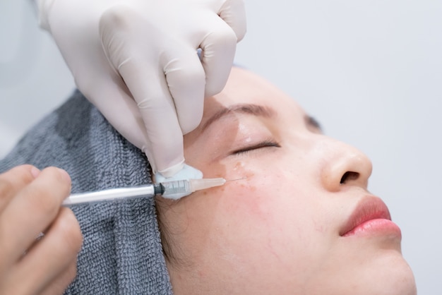 Mãos de médicos fazendo um cosmético de injeção no rosto de mulher jovem. tratamento de beleza. Foto Premium