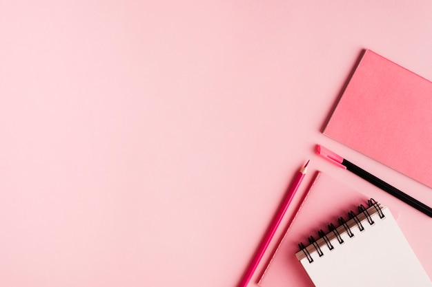 Material de escritório-de-rosa na superfície colorida Foto gratuita