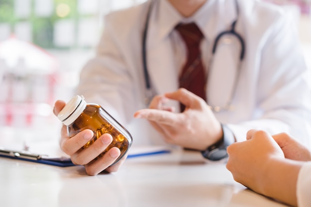 Médico dando mulher introdução aos cuidados de saúde com um óleo de peixe, ômega 3 cápsulas em garrafa. Foto Premium