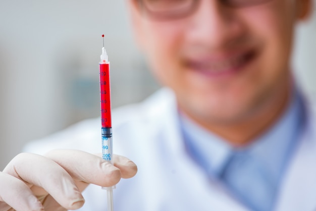 Médico trabalhando com amostras de sangue Foto Premium