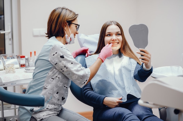 Menina bonita sentada no consultório do dentista Foto gratuita