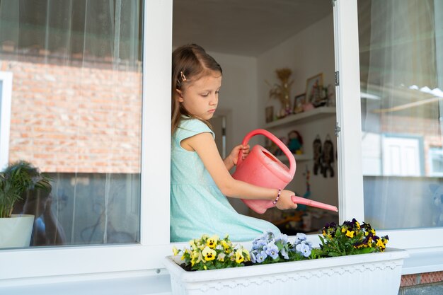 Menina Crian A Regando De Um Regador Regando Flores Do Lado De Fora Da