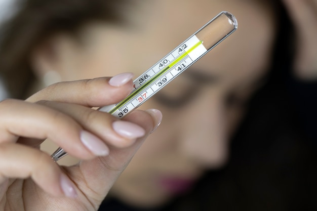 Menina doente com febre alta mostra termômetro médico com 42,2 graus | Foto  Premium