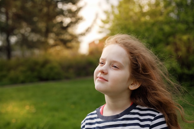 Menina fechou os olhos e respirando com ar fresco soprando. Foto Premium