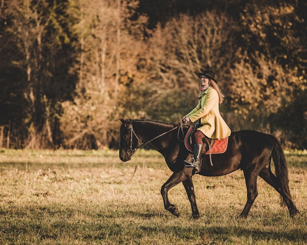 Menina montar um cavalo Foto gratuita