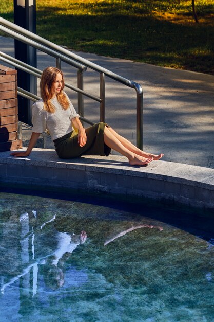 Menina relaxante sob o sol perto da água no dia quente sensual Foto Premium