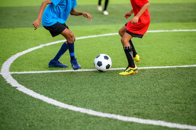 Meninos jogando futebol no campo de treino de futebol Foto Premium
