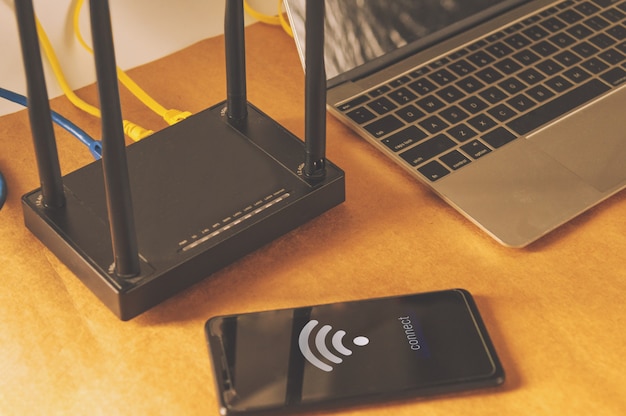 Mesa de escritório plana leigos com roteador wifi, computador e suprimentos vista superior Foto Premium