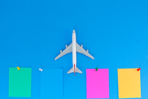 Modelo de avião com nota de papel de pau no fundo azul com espaço de cópia Foto Premium