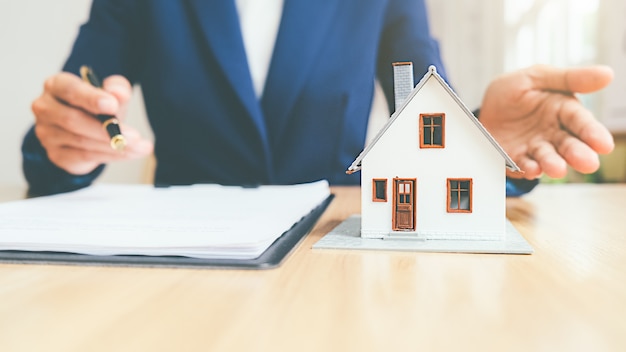 Modelo de casa com agente imobiliário e cliente discutindo contrato para comprar casa, seguro ou empréstimo conceito imobiliário Foto Premium